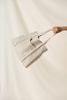 a person is holding a piece of linen in their hand and pulling it with two handles