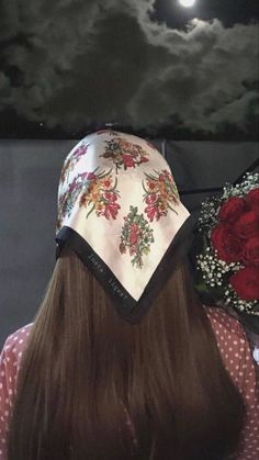 the back of a woman's head wearing a bandana with flowers on it