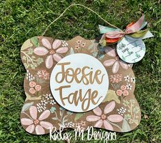 a wooden sign that says jesie fane on it with flowers and leaves around it