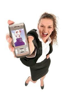 a woman in business attire holding up a cell phone