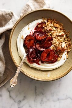 a bowl filled with yogurt, strawberries and granola