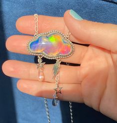 "Celestial Magic to wear around your neck! Featuring vibrant Aurora Opal/Glass Doublets in two shapes; Rainbow Crescent Moon Rainbow Cloud Sterling Silver Charms \"Magical\" hand stamped on back Hand wire wrapped Aura Quartz Rain Drops Sturdy Sterling Silver Oval Cable chain with 20, 18, and 16 inch adjustments Lobster claw clasp closure ⚡️⚡️⚡️⚡️⚡️⚡️⚡️⚡️⚡️⚡️⚡️⚡️⚡️⚡️⚡️⚡️ Do not submerge in water and use a jewelry polishing cloth to clean. This listing is for one pendant necklace only 🌈Aurora Opa Celestial Necklace For Festivals, Iridescent Adjustable Necklace For Festivals, Adjustable Iridescent Necklace For Festivals, Unique Iridescent Jewelry For Festivals, Silver Glass Jewelry For Festival, Handmade Celestial Iridescent Necklace, Handmade Iridescent Celestial Necklace, Handmade Multicolor Celestial Jewelry, Celestial Pendant Necklaces For Party