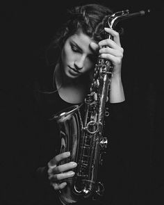 a woman holding a saxophone in her hands