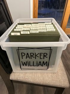 a plastic container filled with papers sitting on top of a chair