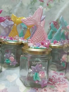 several glass jars filled with little mermaid figurines