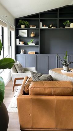 a living room filled with lots of furniture and plants on top of bookshelves