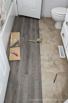 a bathroom with wood flooring and white cabinets