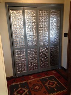 an ornate glass door in the corner of a room with a rug on the floor