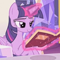 a pinkie is reading a book while sitting at a table