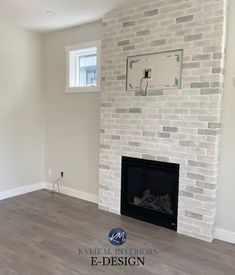 an empty living room with a white brick fireplace