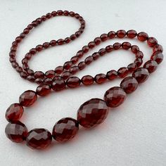 A long strand of old cherry "amber" Bakelite beads necklace with clasp - the 1920 or 1930's probably.  77 beads 35" strand 91cm 4x8mm to 19x25mm .5mm hole 49 grams Vintage Formal Beaded Necklaces With Faceted Beads, Vintage Faceted Round Bead Necklace, Vintage Faceted Round Bead Necklaces, Vintage Single Strand Beads For Formal Occasions, Vintage Formal Necklace With Gemstone Beads, Classic Round Beads For Formal Occasions, Classic Faceted Round Bead Necklaces, Vintage Amber Beaded Necklace With Oval Beads, Vintage Formal Beaded Necklaces With Polished Beads