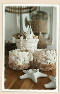 three baskets filled with seashells sitting on top of a wooden table