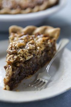 a piece of pie sitting on top of a white plate with a fork next to it