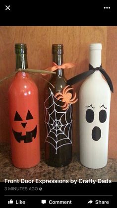 three bottles decorated with halloween decorations on a counter