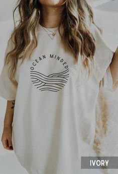 "Minimalist summer tee with simple wave graphic and \"ocean minded\" quote. Cute gift for surfers, coconut girls and granola girls. This is a Comfort Colors T-shirt. A garment-dyed tee made with 100% ring-spun cotton. The soft-washed, garment-dyed fabric brings extra coziness to your wardrobe while the relaxed fit makes it an excellent daily choice. The double-needle stitching throughout the tee makes it highly durable while the lack of side-seams helps the shirt retain its tubular shape.  ✦ SHIRT ✦ * Brand: Comfort Colors * 100% ring-spun cotton * Medium fabric (6.1 oz/yd² (206.8 g/m * Relaxed fit * Sewn-in twill label * Double needle stitching on all seams  * Without side seams ✦ PRINT ✦ * This is a direct-to-garment printed item * The ink is printed into the fabric, not sitting on top o Trendy Beach Cotton Shirt, White Cotton Beach Shirt, Simple Organic Cotton T-shirt For Summer, Simple Organic Cotton Summer T-shirt, Cotton Crew Neck Shirt For Beach, Trendy Organic Cotton Tops For Summer, Relaxed Cotton Shirt For Beach Season, Summer Cotton Crew Neck Shirt, Crew Neck Cotton Shirt For Vacation