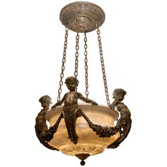 a chandelier hanging from the ceiling with statues on it