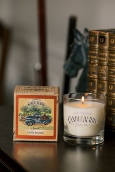 a candle is sitting on a table next to an old box and some books in the background