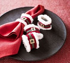 a black plate topped with red napkins and santa hats