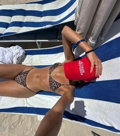 a woman laying on top of a blue and white towel