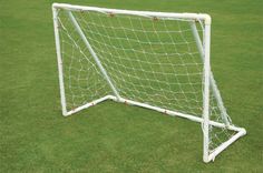 a soccer goal on the grass with red balls