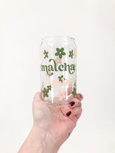 a person holding up a clear glass with shamrocks on the bottom and matching name