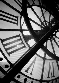 a black and white photo of a clock with roman numerals