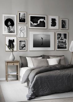 a bedroom with gray walls and pictures on the wall above the bed in front of it