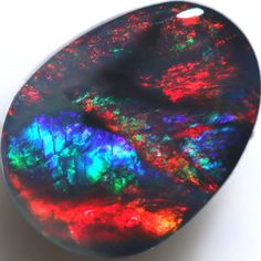 an opalite stone is shown on a white surface with red, green and blue colors