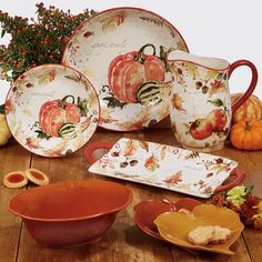 a table topped with plates and bowls covered in fall themed dishes on top of a wooden table