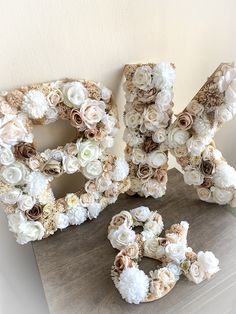 the letters are made out of flowers and burlucks on top of a table