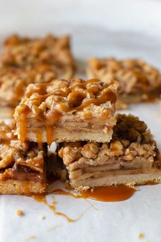 three pieces of dessert sitting on top of a white plate with caramel drizzle