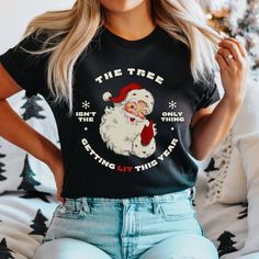 "This hilarious \"The Tree Isn't The Only Thing Getting Lit This Year\" Christmas shirt is a perfect way to show off your festive spirit while also bringing a smile to everyone's face. With a clever play on words, this shirt features a retro Santa Claus with the funny Christmas phrase written around the image. It's sure to be a hit at any holiday gathering or party. How To Order Your New Favorite Santa Claus T-Shirt: 1) Please, Check and Review all Photos. 2) Select Your T-shirt Size and Color. 3) Choose Your Quantity (as many as you want). 4) Click \"Go to Cart\" and Fill out payment information.  5) Click \"Checkout\" T-Shirt Description: ◆ PREMIUM UNISEX SHORT SLEEVE JERSEY TEE Unisex, ultra soft, tightly knit Shoulder to shoulder taping Cover stitched collar and sleeves Shoulder to sho Christmas Pajama Party, Christmas Phrases, Retro Santa, Funny Xmas, Xmas Shirts, Vinyl Ideas, Funny Christmas Shirts, Xmas Party, Holiday Gathering