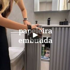 a woman in a black dress standing next to a white toilet and sink with the words papeleria embuida on it