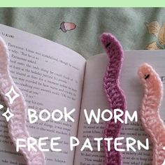 two crocheted worms sitting next to each other on top of an open book