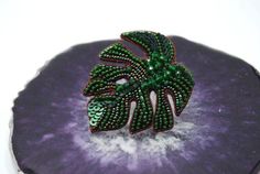 If you love botanical jewelry, this big green monstera leaf brooch is something you wouldn't pass by. It's a beautiful and unique statement pin brooch with fancy beadwork embroidery. It's completely hand embroidered with the best quality sequins and seed beads. Great choice for all lovers of tropical plants and beaded jewelry, freshens any look and will never pass unnoticed.Size: 4*4 cm (1.6*1.6 in)Materials: sequins, seed beads, cannetille, metal pin. Cream Bridesmaids, Unique Green Beaded Brooches, Plant Jewelry, Beadwork Embroidery, African Necklace, Botanical Jewelry, Bird Brooch, Valentines Necklace, Chunky Crochet