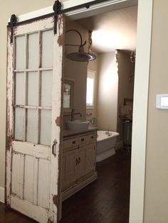 an open door leading to a bathroom with french doors on the inside and outside,