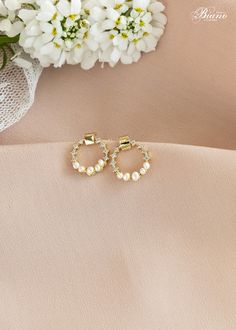 The round shape is simple and minimalist. These dainty pearl hoop earrings can be suitable for any occasion as daily wearing. Accented with a pearl, these elements work to create a stunning and elegant addition to your earring collection. - Earrings features Cubic Zirconia crystals and freshwater pearls - Length: 1.4 cm/0.5 inches - Available Finish: gold  - Nickel and Lead Free - Perfect jewelry to complete your wedding day look or to gift to bridesmaids - This item comes in a signature box Rea Dainty Round Bridal Earrings For Formal Occasions, Dainty Round Wedding Earrings, Dainty Pearl Earrings For Party, Dainty Round Earrings For Wedding, Gold Minimalist Bridal Earrings, Minimalist Round Pearl Earrings For Party, Elegant Halo Hoop Earrings For Weddings, Gold Circular Earrings For Wedding, Delicate Bridal Earrings For Anniversary