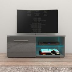 an entertainment center with a television on top of it and a remote control in front of it