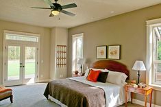 a bedroom with a large bed and two windows