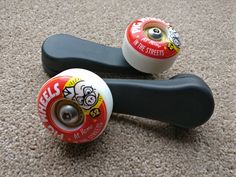 two skateboard wheels sitting on top of a carpeted floor next to each other