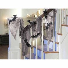 halloween decorations on the banisters of a house with bats hanging from it's railing