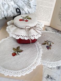 three round doily with cherries on them sitting next to an open book,