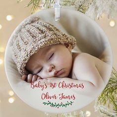 a baby's first christmas ornament hanging from a tree