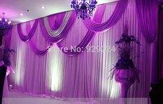 purple wedding decor with chandelier and drapes on the wall for an elegant look