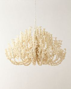 a white chandelier hanging from a ceiling in a room with no one around it