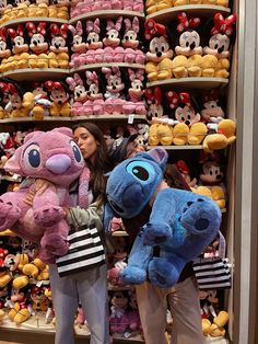 two women are standing in front of some stuffed animals