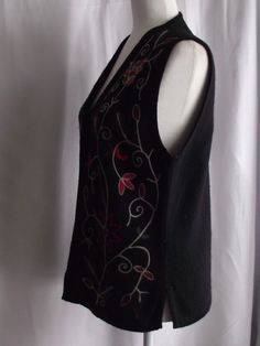 "This beautiful embroidered vest can go from casual to semi-formal with just a few quick changes. Made of a jet black wool, heavy thread, similar to cording forms the designs of flowers and foliage for wearable art. Small side seam open vent gives you more space when sitting. V-neck design with a button front makes it easy to grab and go. No stains, snags or damage. Some light pilling, typical of wool. Please view all my photos. This a Dry Clean Only Garment. Please view all my actual measuremen Celtic Embroidery, Woodland Cabin, Embroidered Vest, Rosie The Riveter, Wool Vest, Easter Dress, Cottage Chic, Black Wool, Jet Black