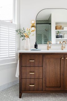 a bathroom vanity with two sinks and a large mirror