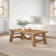 a living room with a white couch and wooden coffee table in front of a window