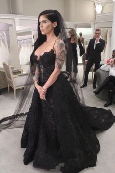 a woman in a black wedding dress standing on the floor